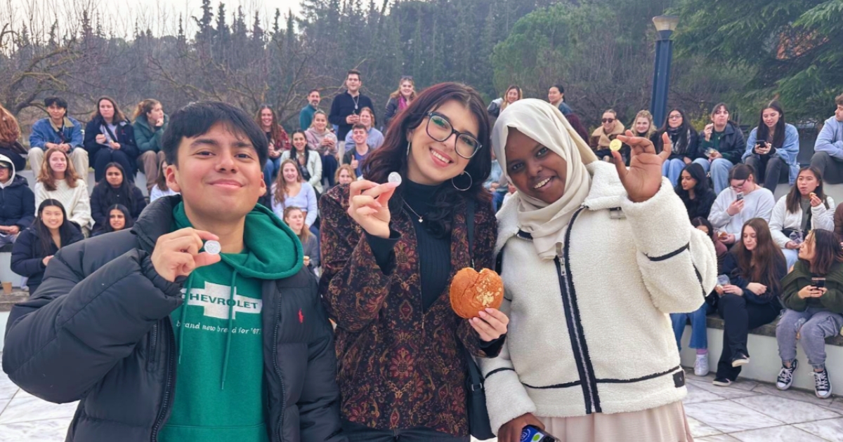 Group of Cornerstone Greece students smiling and holding up coins
