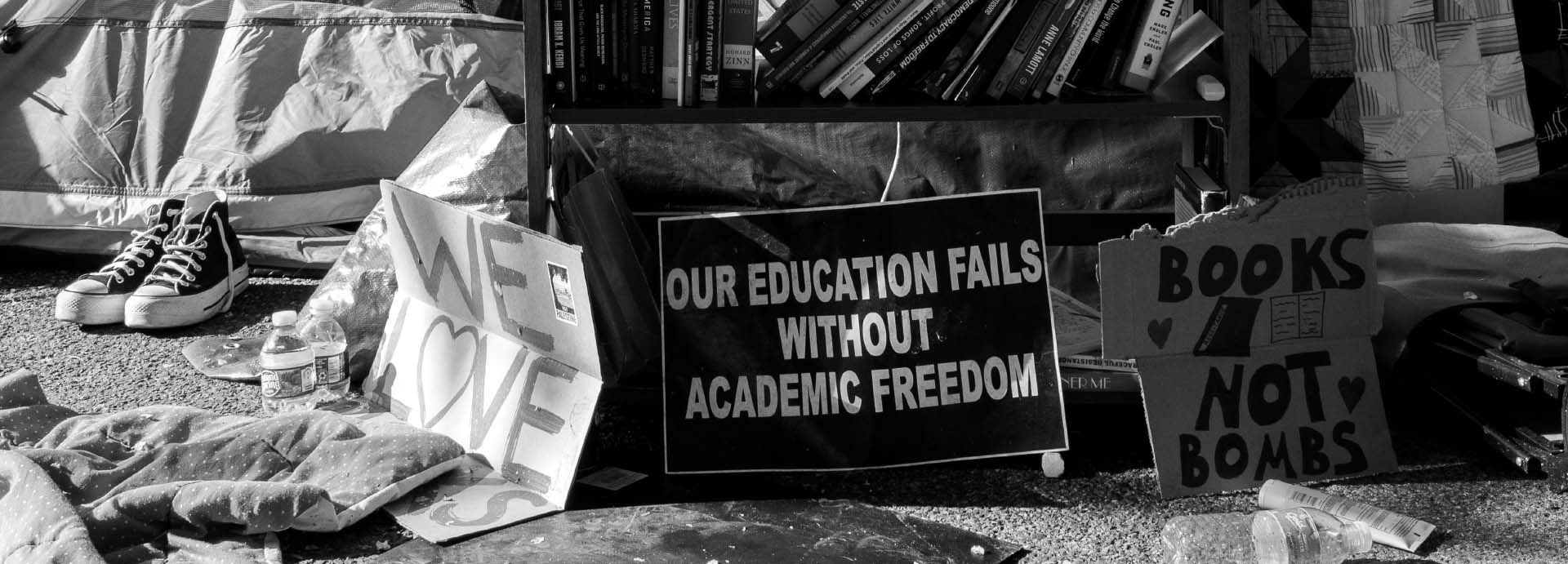 Shoes, American flag, book cart, signs reading we love books, our education fails without academic freedom, books not bombs.
