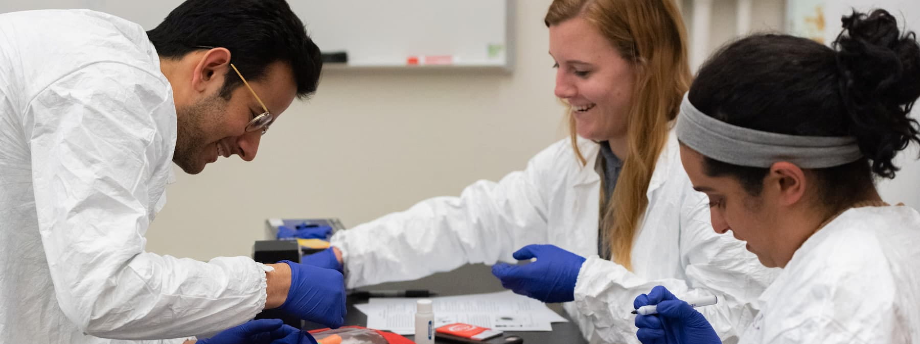 3 AU students in a health lab class.