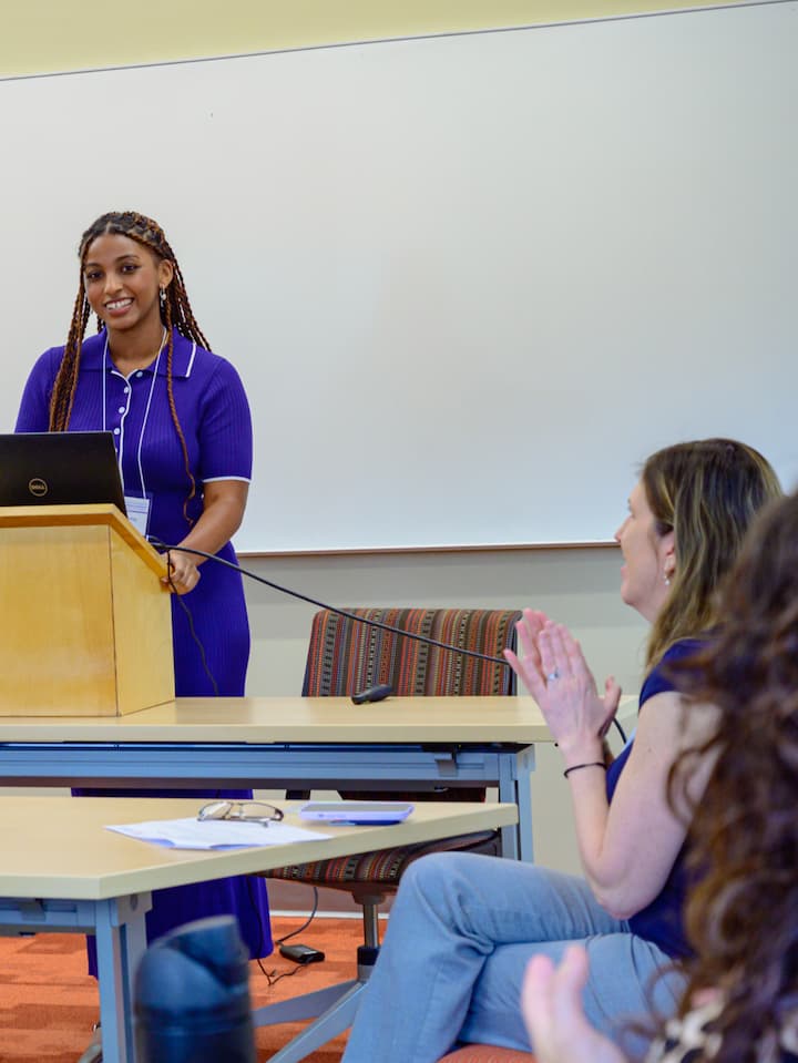 AU student presenting at podium.