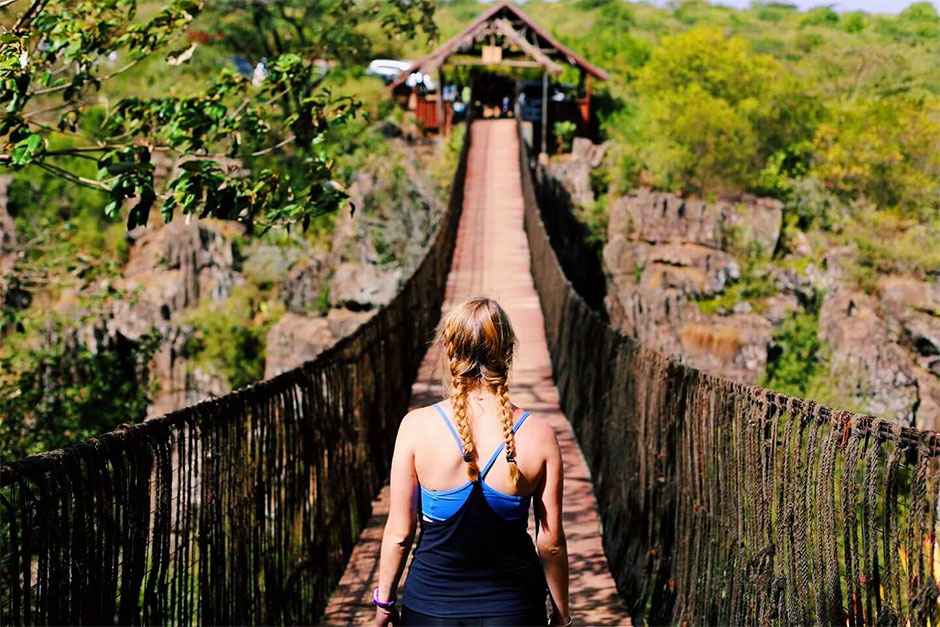 Student on footbridge across a gorge.