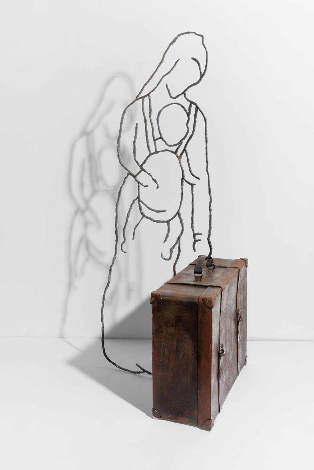  Orna Ben-Ami, Transparent 7, 2020. Outline of a mother with baby strapped to her, holding solid metal suitcase. 