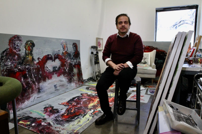 Andres Izquierdo in his studio in front of paintings