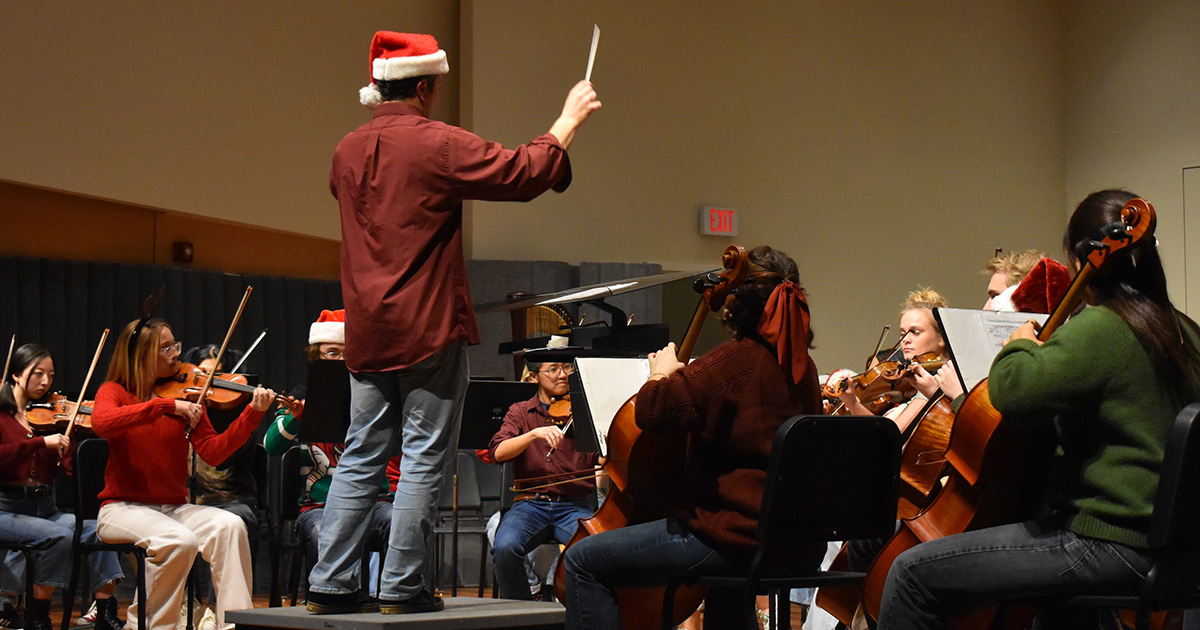 Orchestra and conductor wearing Santa hat