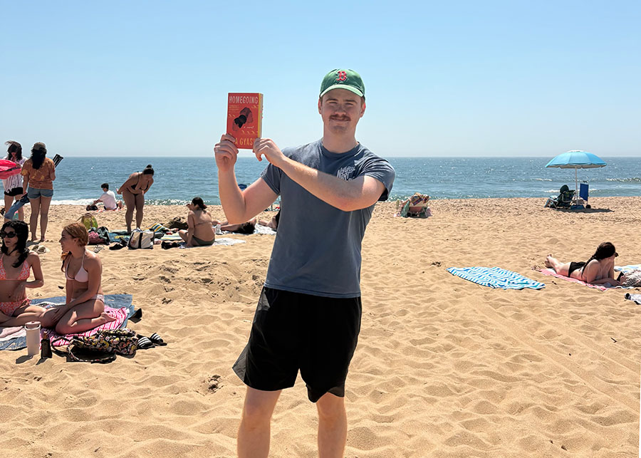 Colin Szustakowski on the beach with Yaa Gyasi’s Homegoing 