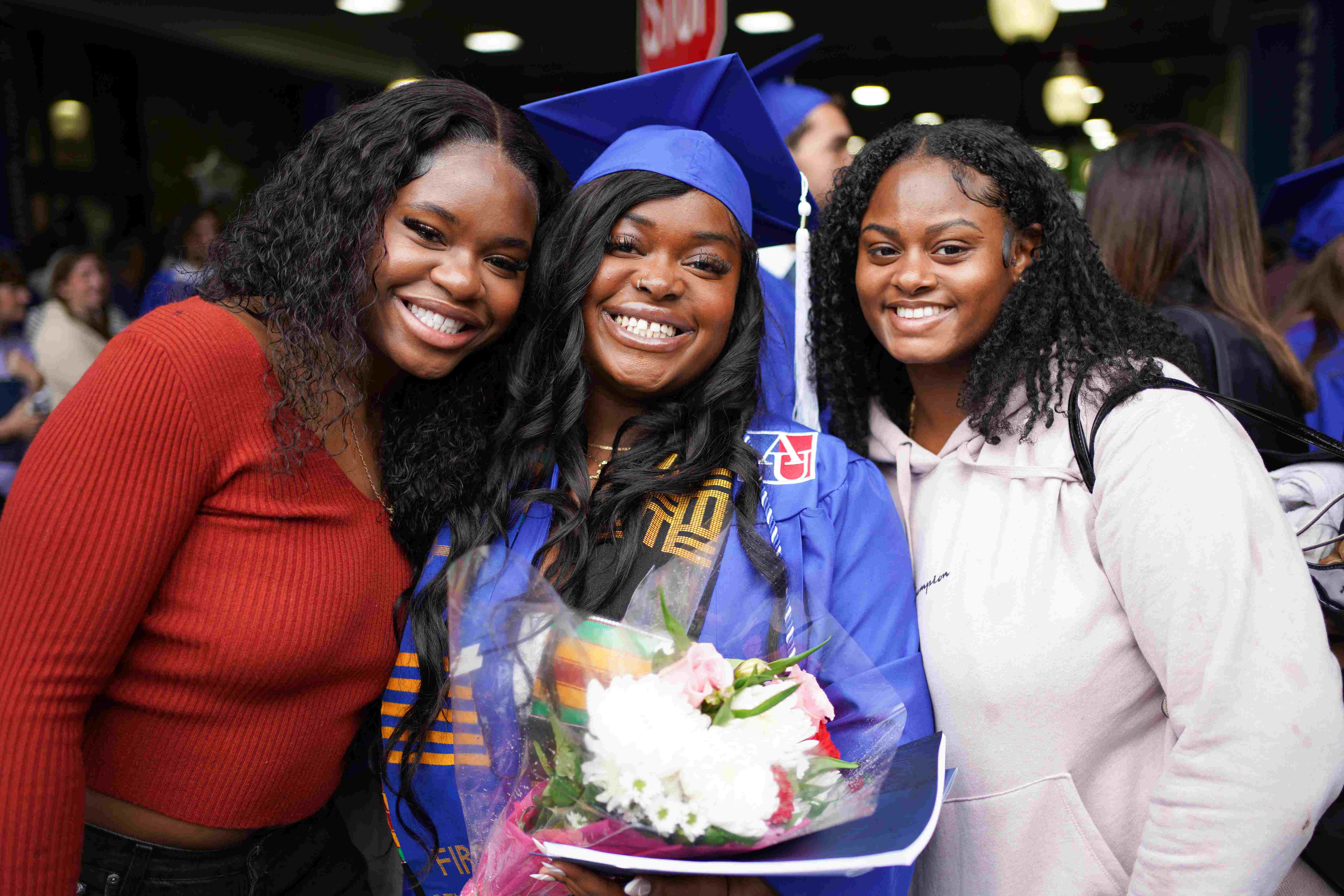 a graduate standing with her family members after commencement