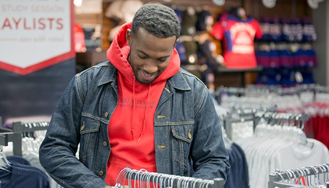 A student looking at clothes in the campus store