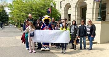 Participants in Bring Your Child to Work Day pose with Clawed Z. Eagle in front of Mary Graydon Student Center. Photo by Andie Rowe.