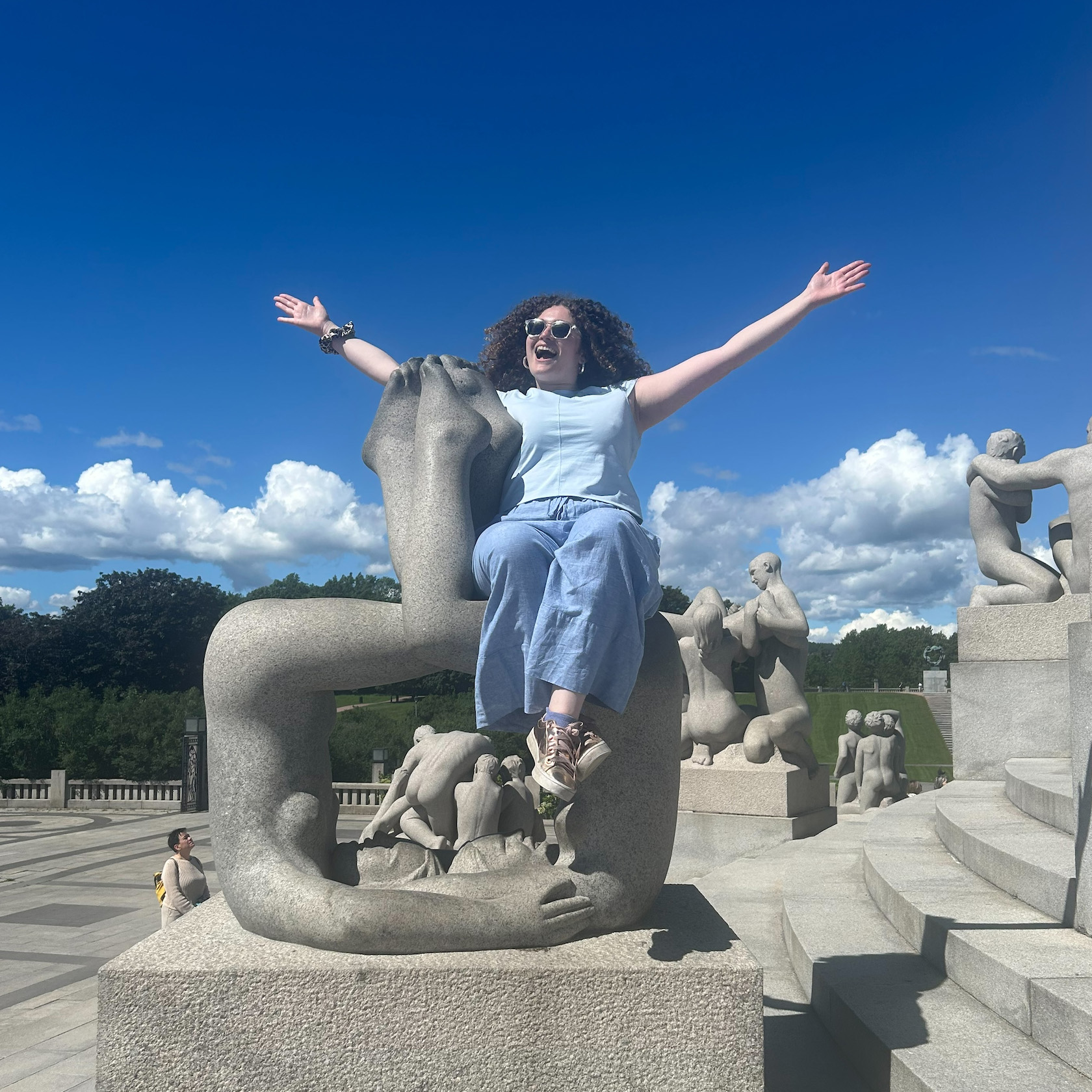 Lucia sitting on a statue, excited