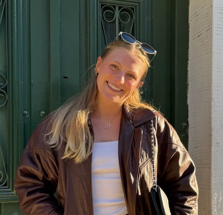 Sabrina Robaczynski, staning in front to a green door