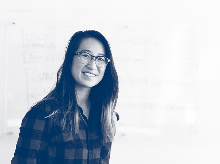 Smiling master's degree candidate at a white board.