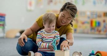 A special education teacher and student interact in a classroom
