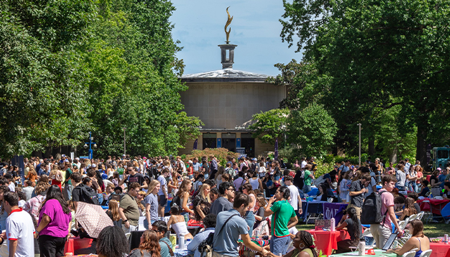 A large crowd of students are gathered on the Quad for the Student Involvement Fair. Kay Spiritual Life Center is in the background.